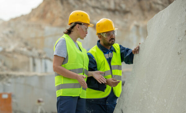2 people with construction hats on at a stone quarry